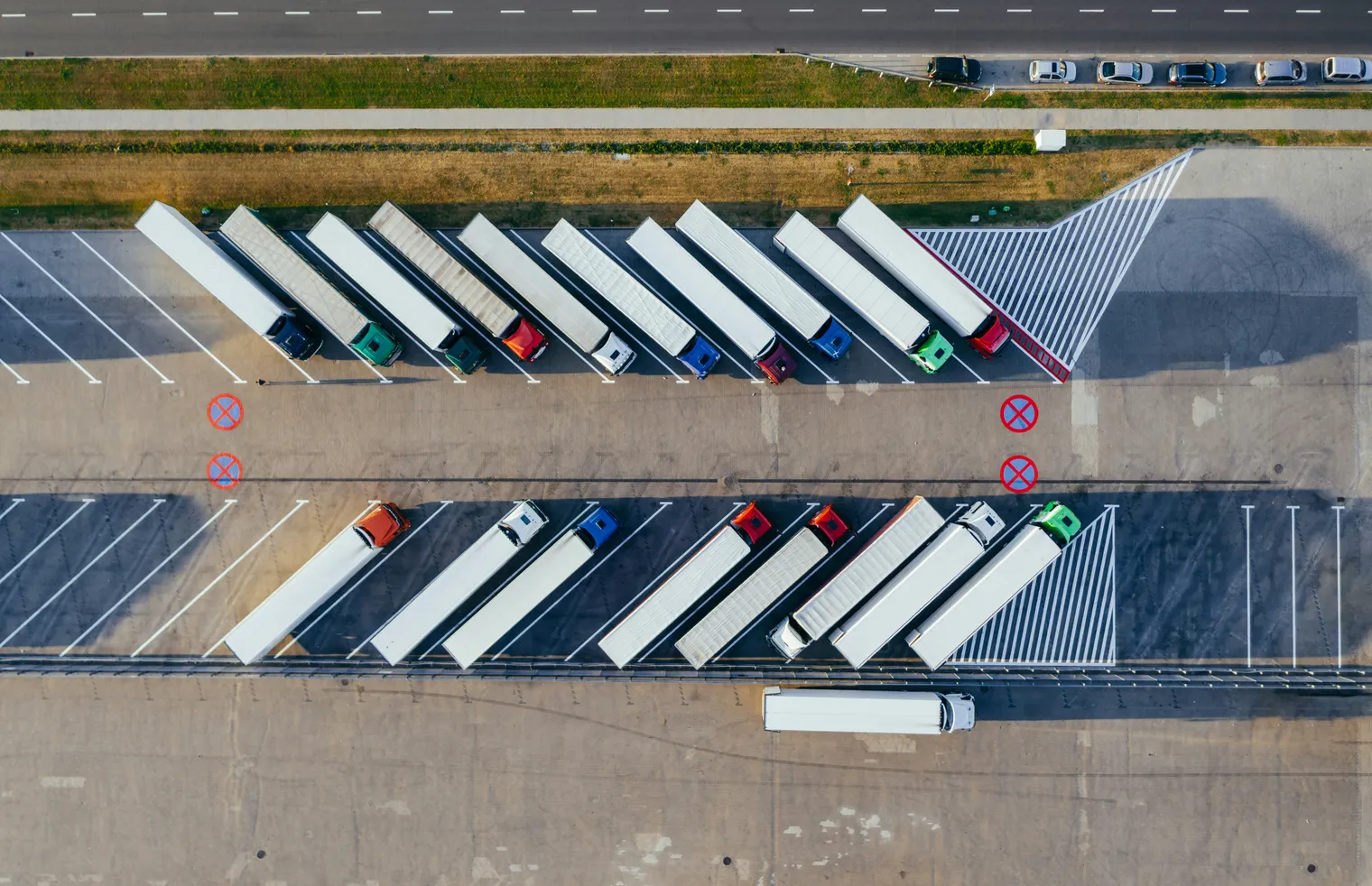 Aerial view of freight trucks lined up at a logistics terminal